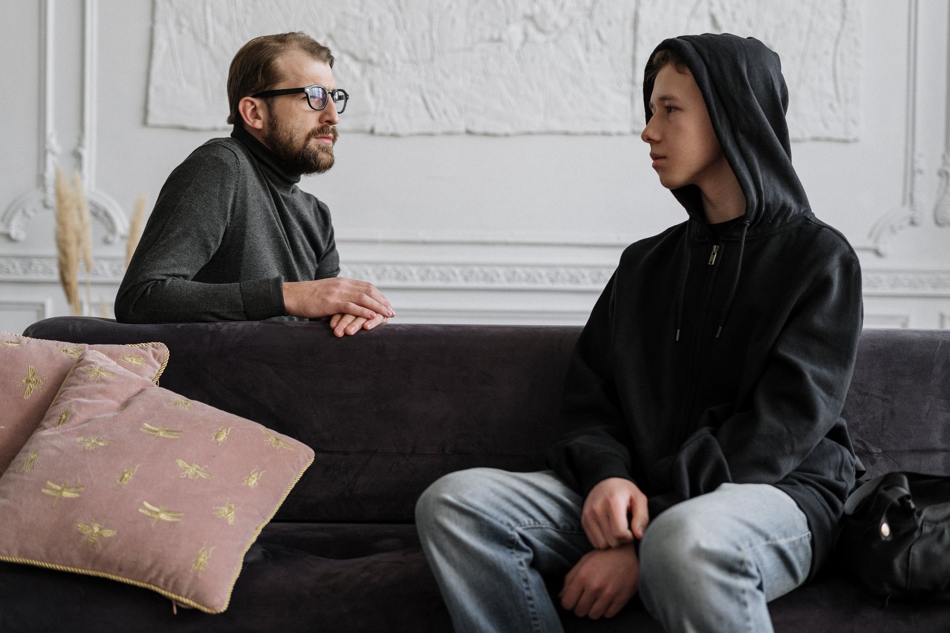 man-in-black-jacket-sitting-on-brown-couch-4100424
